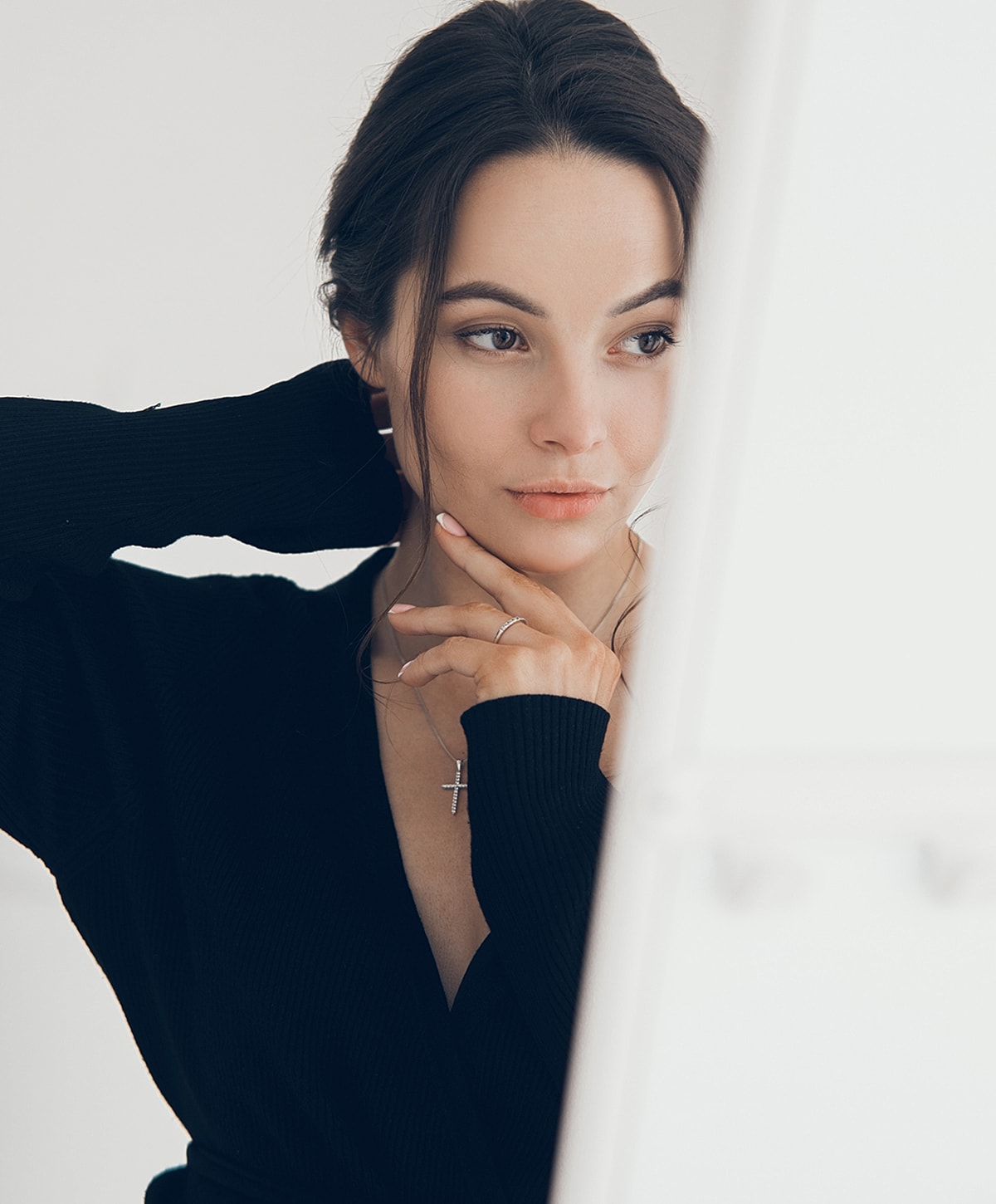 Woman thoughtfully posing in front of a mirror