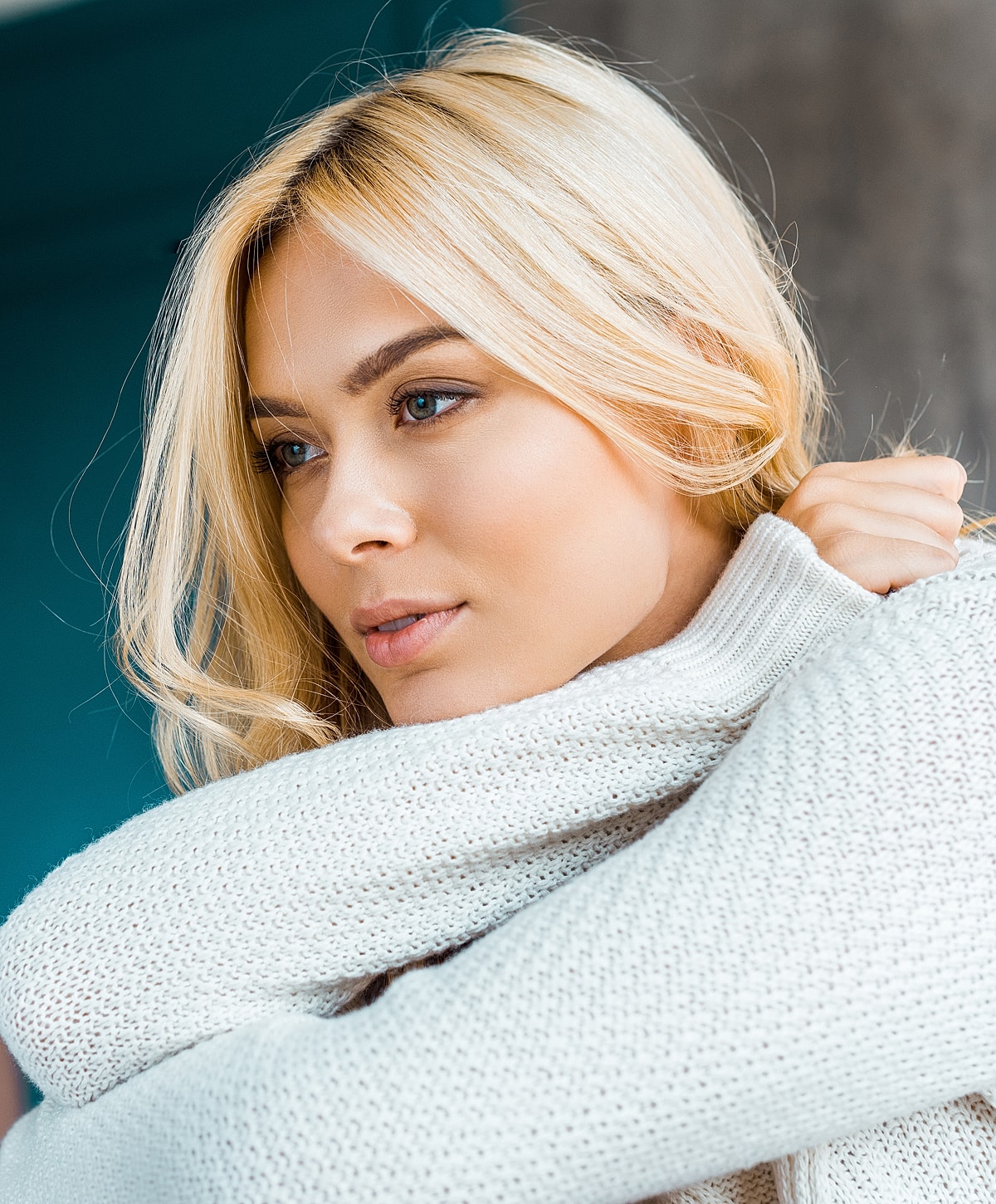 Woman with blonde hair in cozy sweater.
